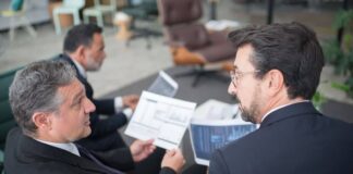Operatori finanziari analizzano documenti relativi a una cartolarizzazione STS di crediti leasing.