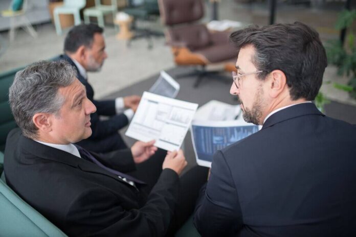 Operatori finanziari analizzano documenti relativi a una cartolarizzazione STS di crediti leasing.