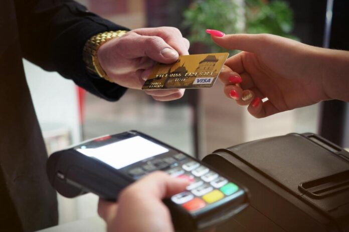 Pagamento contactless con carta su terminale POS in un negozio italiano.