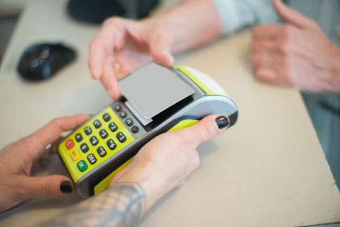 Cliente effettua un pagamento digitale con carta di debito su terminale Pos.